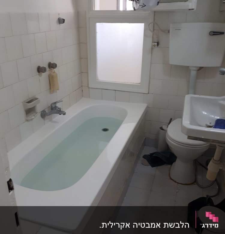 אמבטיה עם חיפוי אריחים לבנים וברז כסוף